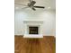 Elegant fireplace in a room with hardwood floors, featuring a white mantel and filled with firewood at 7412 Barberry Ct, Raleigh, NC 27615