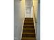 Wooden stairs leading to the upper level with a white door at the top at 7412 Barberry Ct, Raleigh, NC 27615