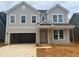 Two-story home with light gray siding, black roof, and an attached garage at 788 Old Station Pointe, Angier, NC 27501