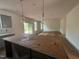 Spacious living room with a kitchen island and sliding glass doors to the backyard at 788 Old Station Pointe, Angier, NC 27501