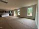 A spacious living room with large windows, showcasing natural light and an open layout to the kitchen at 788 Old Station Pointe, Angier, NC 27501
