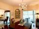 Dining room featuring a chandelier, hardwood floors, and views into a sunroom at 8 Greenside Ct, Durham, NC 27707