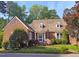 Charming brick home with a well-manicured lawn, mature trees, and a decorative wrought iron fence at 8 Greenside Ct, Durham, NC 27707