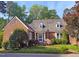 Charming brick home with well-manicured lawn, mature trees and manicured shrubbery enhancing the curb appeal at 8 Greenside Ct, Durham, NC 27707