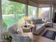 Bright sunroom with large windows and comfortable seating, offering serene views of the outdoors at 8 Greenside Ct, Durham, NC 27707