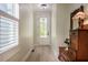 Bright entryway with hardwood floors, decorative chest, and natural light from the adjacent window at 83 Vandalia Ave, Chapel Hill, NC 27516