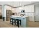 Bright kitchen featuring white cabinets, stainless steel appliances, and a light blue kitchen island at 83 Vandalia Ave, Chapel Hill, NC 27516