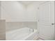 Clean bathroom featuring a soaking tub with tiled accents and natural light at 908 Kensley Grove Ln # 68, Fuquay Varina, NC 27526