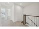 Upstairs hallway with carpet, wooden railing, and doors to bedrooms and closets at 908 Kensley Grove Ln # 68, Fuquay Varina, NC 27526