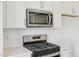Detailed view of a stainless steel gas range and microwave, paired with white subway tile backsplash and quartz countertops at 908 Kensley Grove Ln # 68, Fuquay Varina, NC 27526