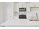 Close-up of the kitchen featuring stainless steel microwave, gas range, white subway tile backsplash, and quartz countertops at 908 Kensley Grove Ln # 68, Fuquay Varina, NC 27526