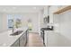 Stylish kitchen with white cabinets, stainless steel appliances, quartz countertops, and access to the backyard at 908 Kensley Grove Ln # 68, Fuquay Varina, NC 27526