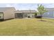 A well-maintained backyard features a lawn, screened porch, patio, and barbecue grill at 10 Currituck Ln, Durham, NC 27703