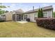 A well-maintained backyard features a lawn, screened porch, patio, and barbecue grill at 10 Currituck Ln, Durham, NC 27703