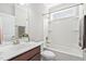 Bright bathroom featuring a single sink vanity, framed mirror, tub-shower combination and a plant on the counter at 10 Currituck Ln, Durham, NC 27703