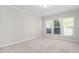 A bright bedroom with carpeted floors and natural light streaming through the windows at 10 Currituck Ln, Durham, NC 27703