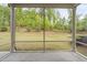 Screened porch showcasing a view of the landscaped backyard with a plush green lawn and mature trees at 10 Currituck Ln, Durham, NC 27703