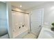 Bright bathroom offers a shower-tub combo, white door, and vanity with a solid surface counter at 1002 Dogwood Bloom Ln, Knightdale, NC 27545