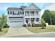 Charming two-story home featuring a welcoming porch, attached garage, and well-manicured lawn at 1002 Dogwood Bloom Ln, Knightdale, NC 27545