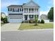 Two-story home featuring a two-car garage, second-story balcony, and black window shutters at 1002 Dogwood Bloom Ln, Knightdale, NC 27545
