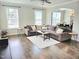 Open concept living room with a large sectional sofa, hardwood floors, and natural light at 1002 Dogwood Bloom Ln, Knightdale, NC 27545
