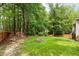 Well-maintained backyard with fire pit and lush green lawn surrounded by mature trees at 1003 Fairfax Woods Dr, Apex, NC 27502