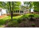 Landscaped backyard with mature trees, screen porch, and lush green lawn at 1003 Fairfax Woods Dr, Apex, NC 27502