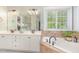 Bright bathroom boasts dual sinks, soaking tub, and neutral color palette at 1003 Fairfax Woods Dr, Apex, NC 27502