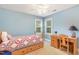 Charming bedroom with wood bed frame, patchwork quilt, and desk with natural light from two windows at 1003 Fairfax Woods Dr, Apex, NC 27502