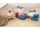 Spacious bedroom featuring a large bed, sitting area with multiple chairs, and natural light at 1003 Fairfax Woods Dr, Apex, NC 27502