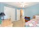Cozy bedroom with blue walls, ceiling fan, wood accent bench, and natural light at 1003 Fairfax Woods Dr, Apex, NC 27502