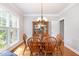 Bright dining room with wood table, chandelier, and a china cabinet by a window at 1003 Fairfax Woods Dr, Apex, NC 27502