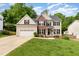 Charming two-story home with brick accents, attached garage, and well-manicured lawn at 1003 Fairfax Woods Dr, Apex, NC 27502
