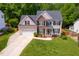 Aerial view of home featuring a well-manicured front yard, garage, and inviting entrance at 1003 Fairfax Woods Dr, Apex, NC 27502