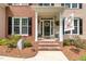 Inviting front porch with brick steps, decorative wreath, and a 'Welcome' flag at 1003 Fairfax Woods Dr, Apex, NC 27502