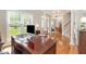Spacious office area with a large desk, hardwood floors, and bright, natural light at 1003 Fairfax Woods Dr, Apex, NC 27502