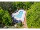 Aerial view of a community pool with lounge chairs and cabanas surrounded by trees at 1003 Fairfax Woods Dr, Apex, NC 27502
