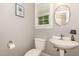 Convenient powder room featuring a pedestal sink and decorative mirror at 1003 Fairfax Woods Dr, Apex, NC 27502