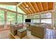 Bright sunroom with lots of windows, vaulted wood ceilings, and comfortable wicker furniture at 1003 Fairfax Woods Dr, Apex, NC 27502