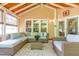 Inviting sunroom with vaulted ceilings, wood beams, comfortable seating, and abundant natural light at 1003 Fairfax Woods Dr, Apex, NC 27502