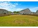 Spacious, fenced backyard with lush green grass and neighboring houses at 1005 Whispering Creek Ct, Knightdale, NC 27545