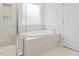 Bathroom featuring a soaking tub with tile surround and a glass enclosed walk-in shower at 1005 Whispering Creek Ct, Knightdale, NC 27545