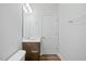 Well-lit bathroom with a single wooden vanity, a mirror, and standard toilet at 1005 Whispering Creek Ct, Knightdale, NC 27545