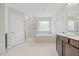 Bathroom features a soaking tub, walk-in shower with glass door, double sink vanity and tile floor at 1005 Whispering Creek Ct, Knightdale, NC 27545
