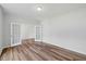 Clean bedroom featuring hardwood floors, white walls, and double doors creating an open feel at 1005 Whispering Creek Ct, Knightdale, NC 27545