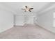 Spacious bedroom with neutral carpet, ceiling fan, tray ceiling, and ample natural light at 1005 Whispering Creek Ct, Knightdale, NC 27545