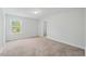Neutral bedroom featuring plush carpet and one window with view of the backyard at 1005 Whispering Creek Ct, Knightdale, NC 27545
