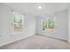 Bright bedroom featuring plush carpet, fresh neutral paint, and large windows with view of backyard at 1005 Whispering Creek Ct, Knightdale, NC 27545