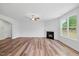 Spacious living room with a cozy fireplace, ceiling fan, and large windows providing natural light at 1005 Whispering Creek Ct, Knightdale, NC 27545