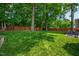 Lush backyard featuring a well-maintained lawn, mature trees, and privacy fence at 10113 San Remo Pl, Wake Forest, NC 27587